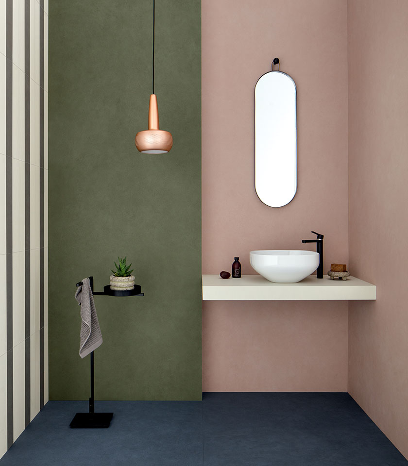 Modernes Bad mit grünen und rosafarbenen Wänden, klaren Oberflächen und minimalistischen Designdetails.