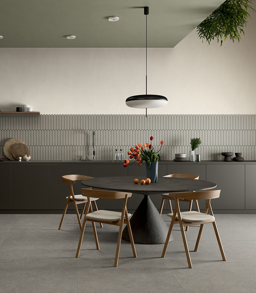 Moderner Essbereich mit dunklem Tisch und Holzstühlen, Boden aus der Kollektion Intense in Steinoptik Crete Clair und dekorativer Wandverkleidung Pills Crete.