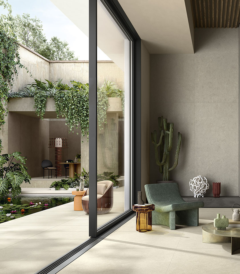 Moderner Indoor-Outdoor-Bereich mit Boden aus der Kollektion Intense in Steinoptik im Farbton Clair, Wandverkleidung im Farbton Perle und Elementen aus der Kollektion Pigmenti im Farbton Pumice.