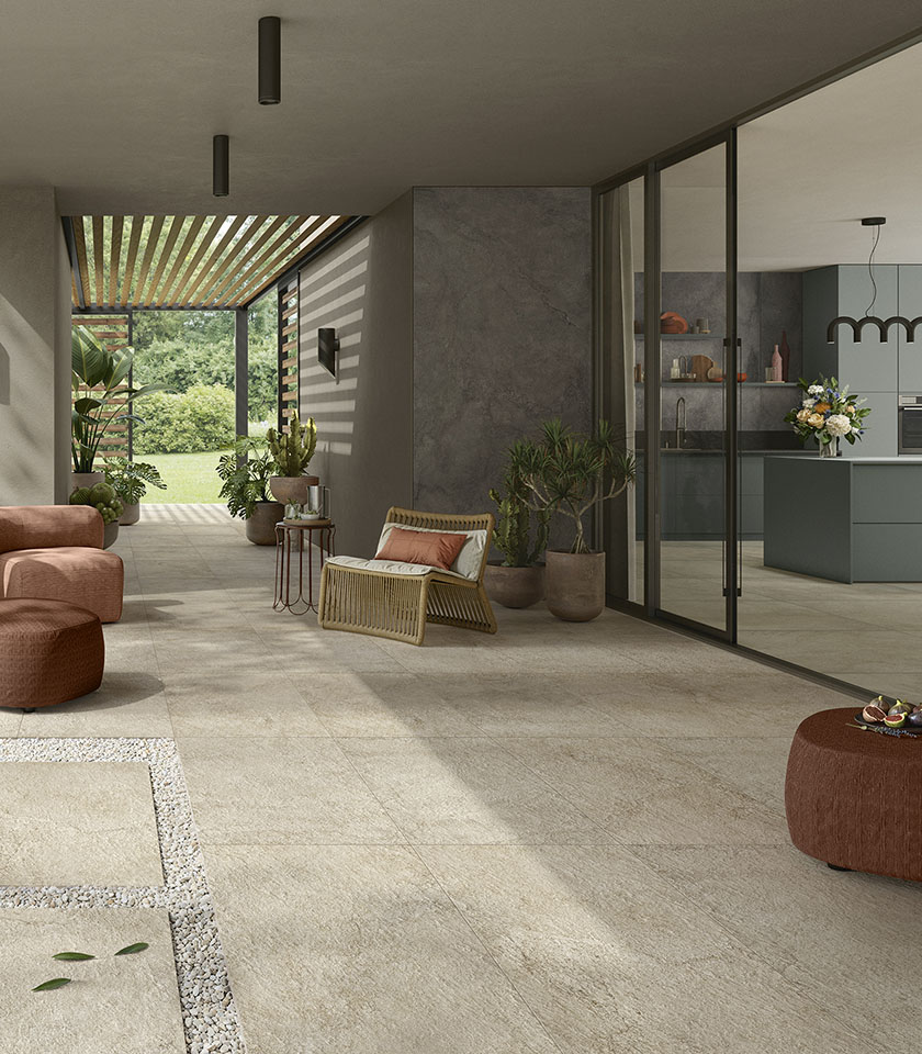 Moderner Indoor-Outdoor-Wohnbereich mit Boden aus der Kollektion Pulse in Steinoptik im Farbton Sand Rough und Wandverkleidungen im Farbton Shadow.