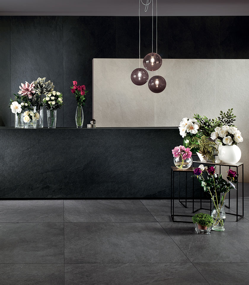 Moderner Raum mit Boden und Wandverkleidungen aus der Kollektion Waterfall in Steinoptik in den Farbtönen Gray Flow, Dark Flow und Ivory Flow.