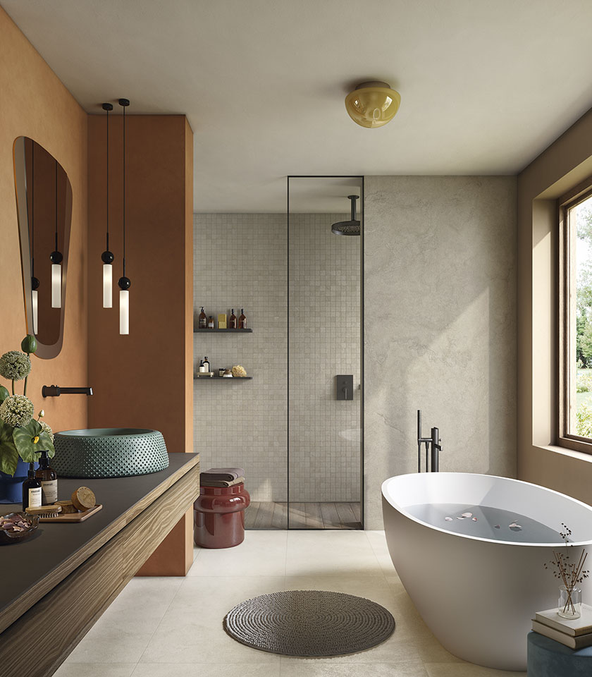 Pulse Shell und Clay gestalten ein helles, materialbetontes Bad, in dem Keramikoberflächen in Steinoptik, Mosaike und warme Farbtöne eine natürliche und moderne Atmosphäre schaffen.