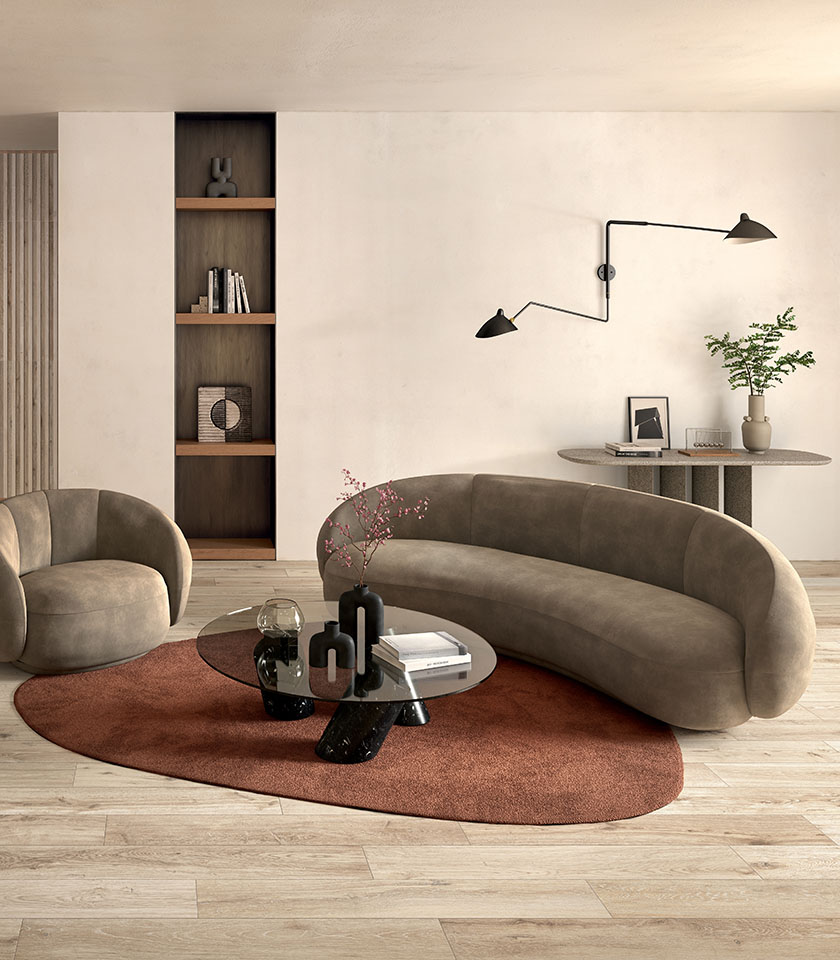 Minimal-Chic-Wohnzimmer mit hellem Boden in Holzoptik, weich geschwungenem Sofa, reduzierter Einrichtung und warmen zeitgenössischen Designdetails.