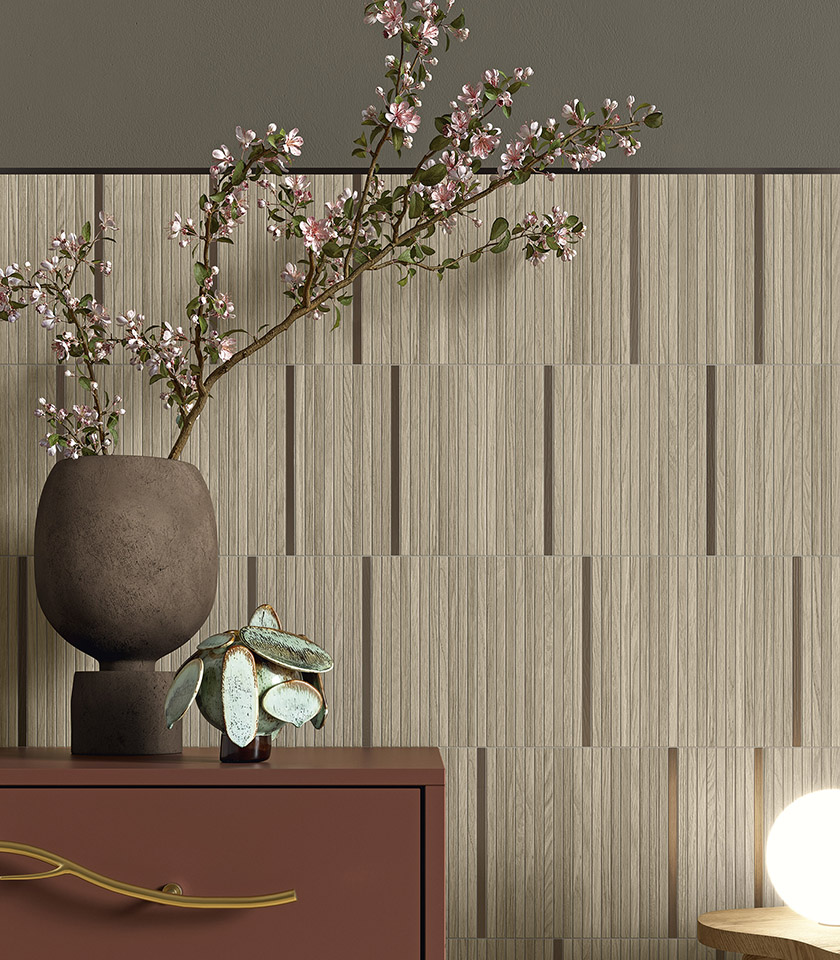 Interieur im Japandi-Stil mit Wandfliesen in Holzoptik, dekorativer Vase mit blühenden Zweigen und Möbeln in natürlichen Farbtönen.