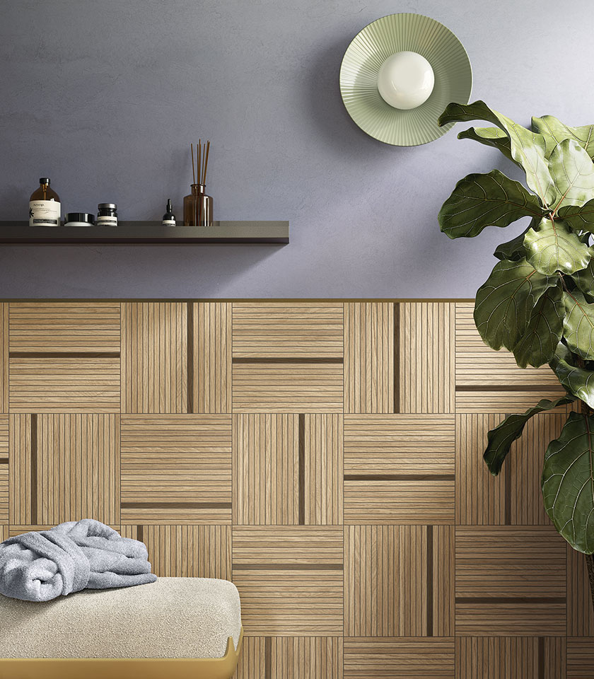 Modernes Badezimmer mit geometrischer Wandverkleidung in Holzoptik, grauer Wand und großer grüner Pflanze.