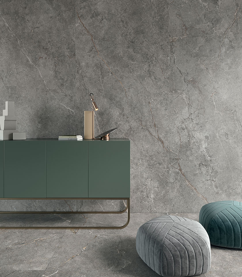 Großformatiger Feinsteinzeugboden in dunkler Steinoptik, von oben mit Beistelltisch, Sitzmöbel und dekorativen Accessoires dargestellt.