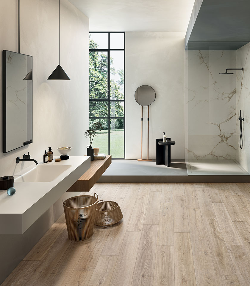 Helles, modernes Badezimmer mit hellem Boden in Holzoptik, Oberflächen in Marmoroptik und minimalistischer Einrichtung für eine elegante und natürliche Atmosphäre.