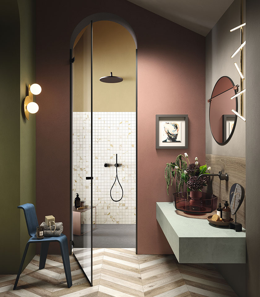 Raffiniertes Badezimmer mit Boden in Holzoptik im Fischgrätmuster, Mosaik in Marmoroptik und warmen Farbtönen für ein originelles, modernes Ambiente.